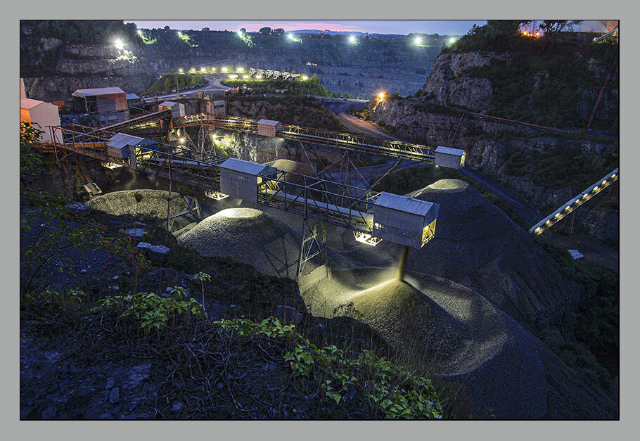 Carrière nocturne - convoyeurs et tas d'agrégats illuminés
